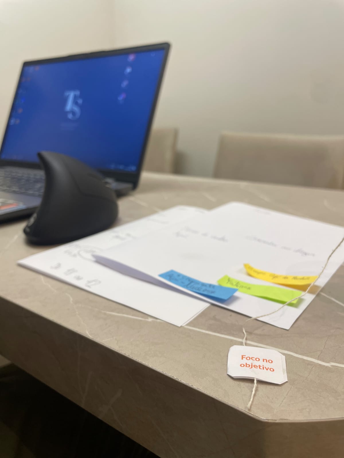 Mesa de atendimento com notebook e materiais de consulta